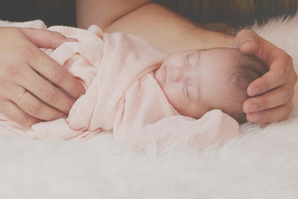 Hands Holding Newborn Baby